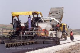 Image du Maroc Professionnelle de  Travaux sur la voie en construction Sidi el Yamani-Asilah installation de la première épaisseur de la couche de revêtement de la chaussée, Mercredi 12 Juin 2002. (Photo / Abdeljalil Bounhar) 